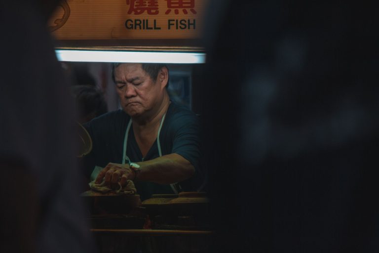 A dedicated street vendor grills fish at a night market in Petaling Jaya, Malaysia.