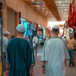 Vibrant street market in Marrakesh, capturing local culture and traditional attire.