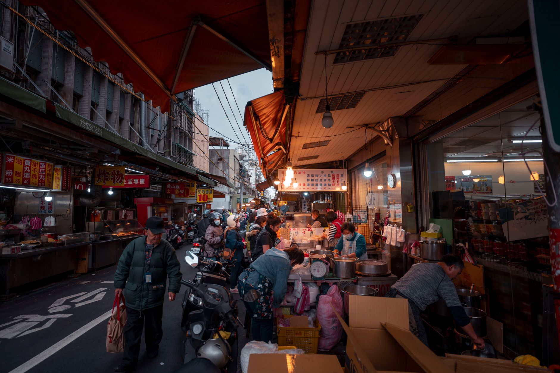 Lively market vendors and shoppers fill an outdoor street market in New Taipei City, Taiwan.